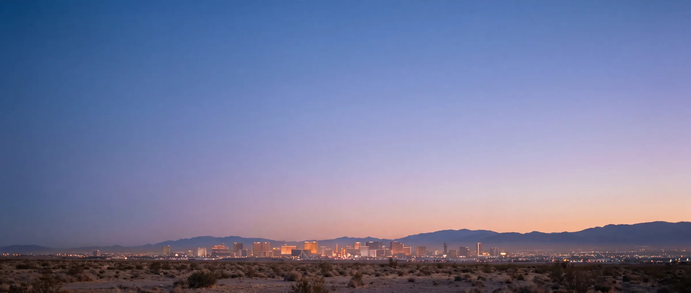 The Las Vegas Strip at blue hour with the mountains behind it